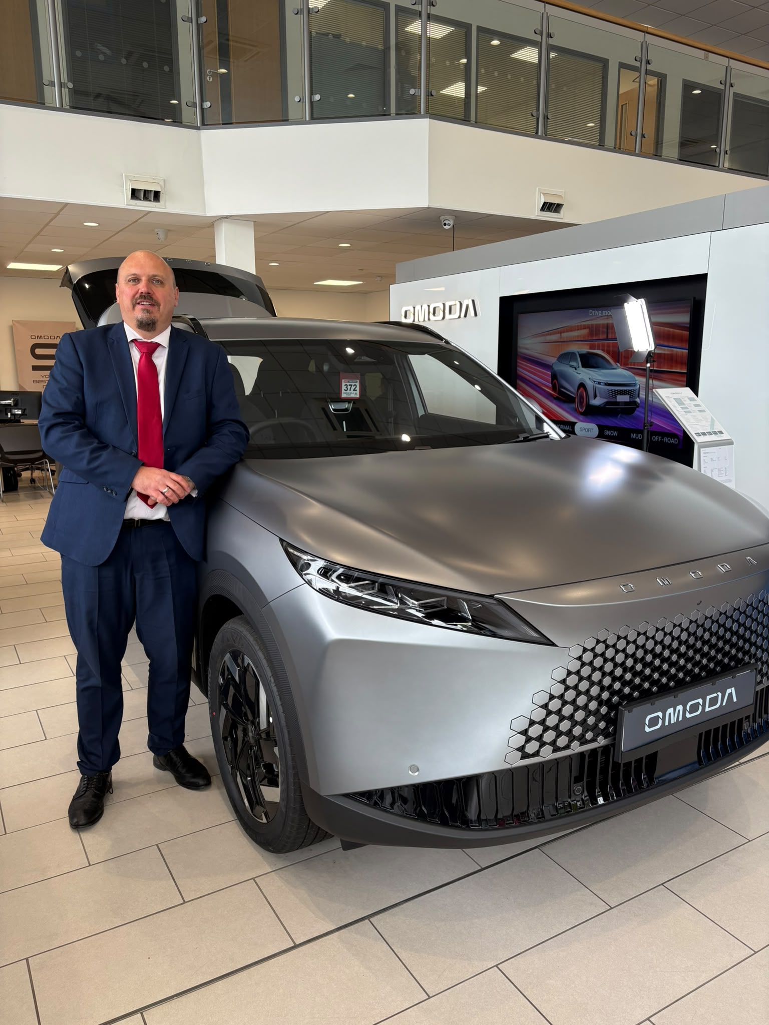 Modern OMODA or JAECOO dealership showroom technology demonstration